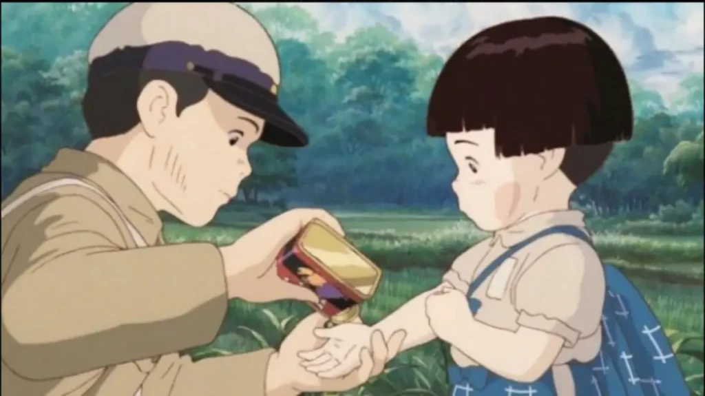 Seita gently pours fruit drops for his little sister Setsuko in Grave of the Fireflies, a poignant Studio Ghibli war drama.