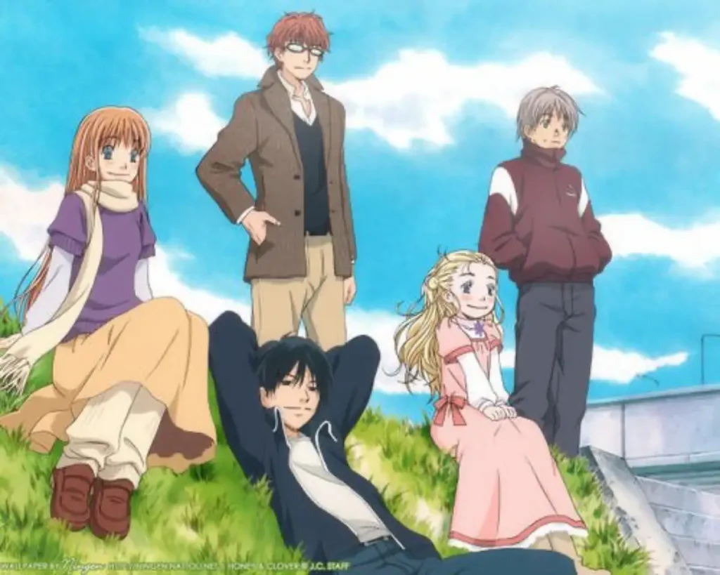 Five friends relax on a grassy riverside bank under a blue sky.