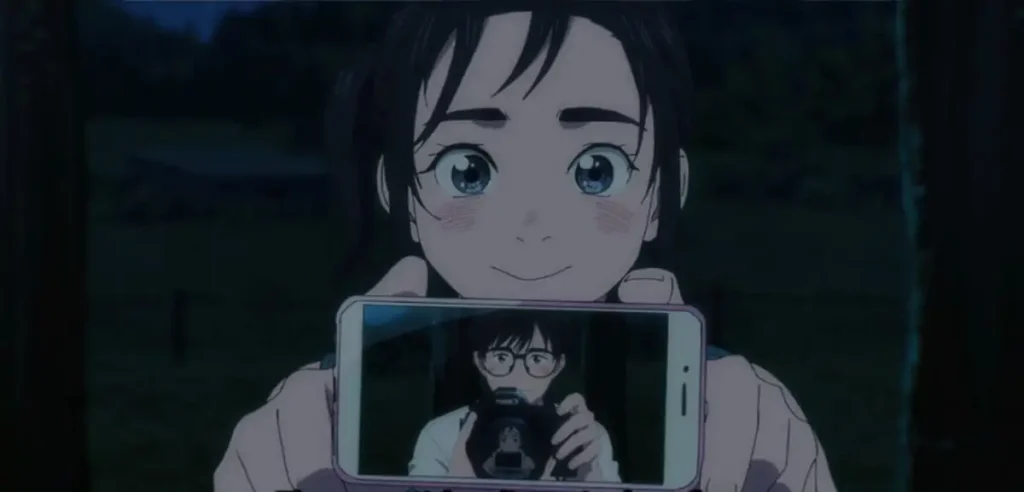 Isaki smiling while holding a phone showing Ganta’s reflection with his camera.