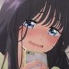 Close-up of a girl with long dark hair holding a phone, blushing nervously.