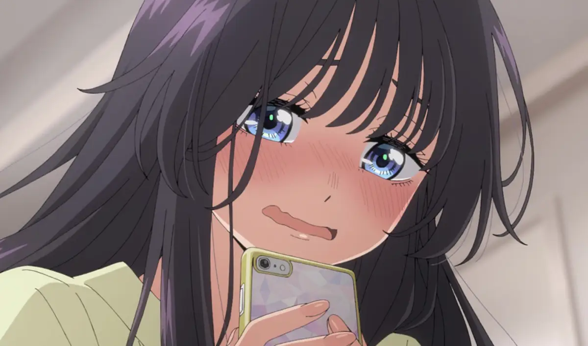 Close-up of a girl with long dark hair holding a phone, blushing nervously.